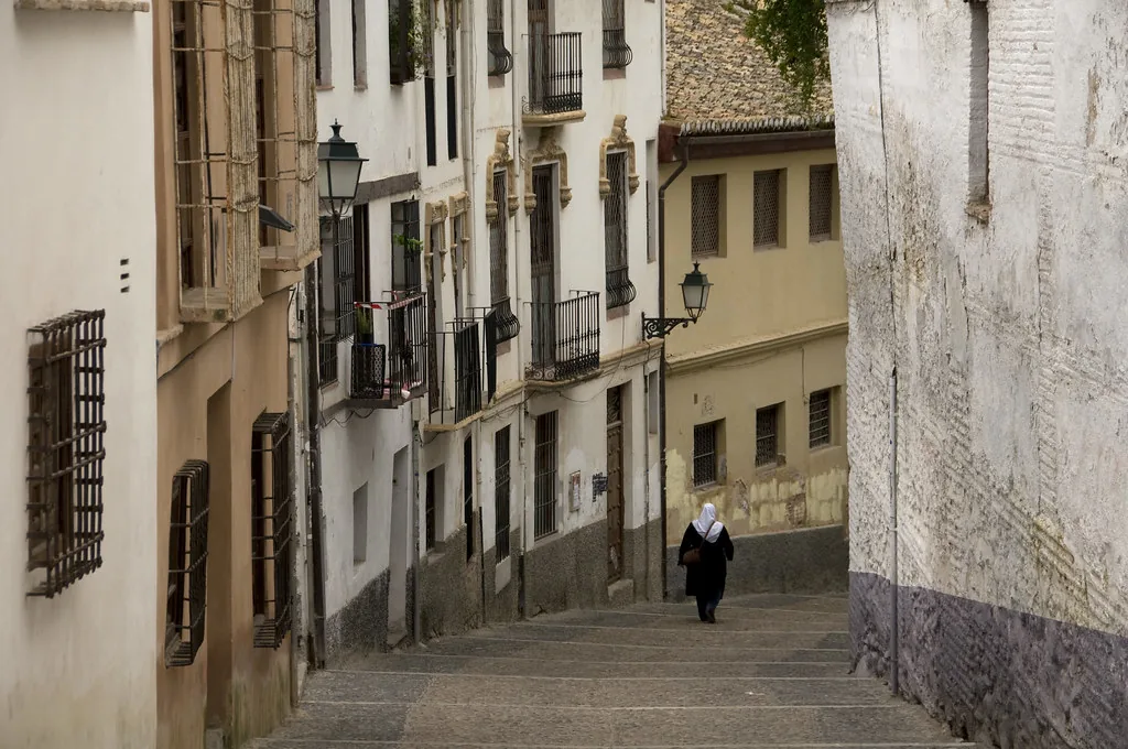 A sunlit plaza in central Granada where layered, smart-casual outfits suit the daytime heat