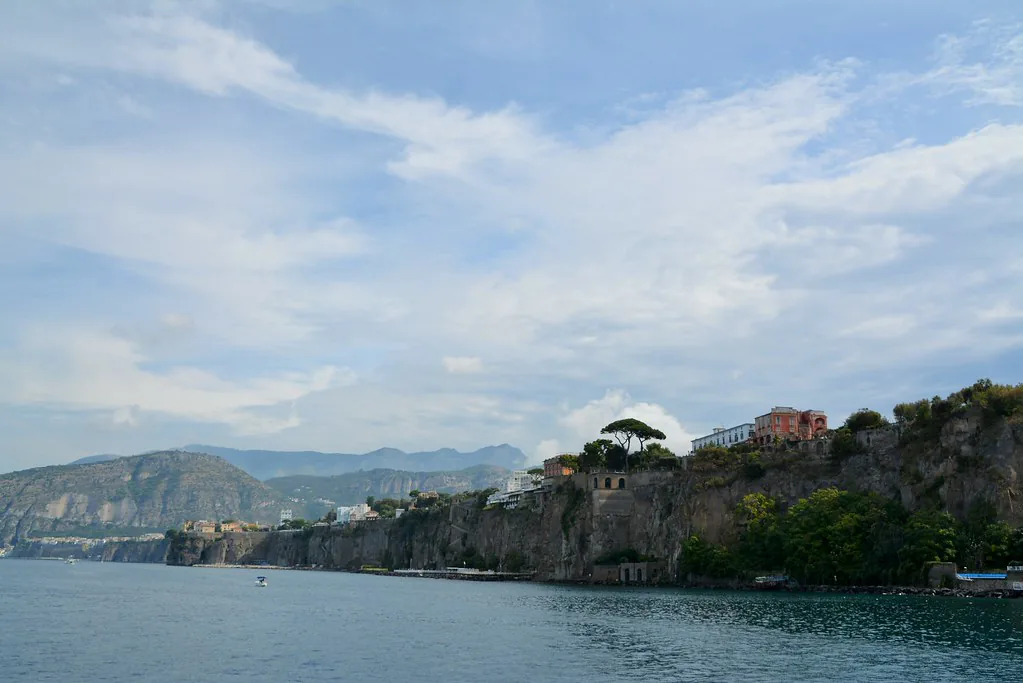 A narrow cobblestone street in Sorrento, Italy lined with shops and pastel buildings