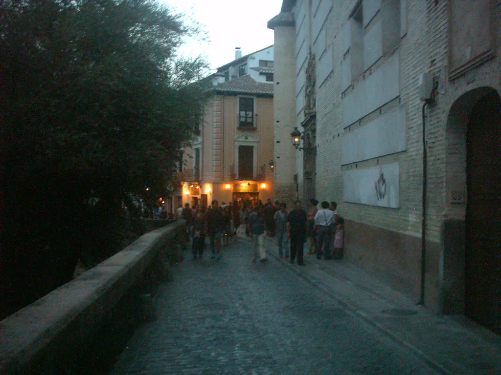 Narrow Granada street at dusk where evening layers keep you warm in June