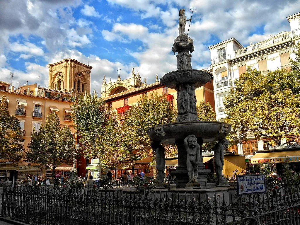 Lively plaza in Granada, Spain with people in spring clothing and outdoor cafes