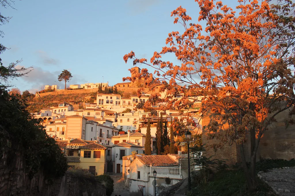 A narrow Granada street in the Albayzín quarter, the kind of steep cobbled lane you dress and pack for in November