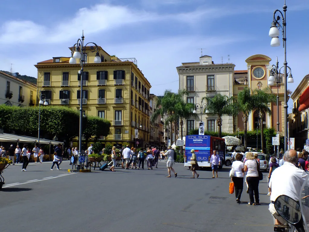 Sunlit street in Sorrento, Italy in summer with travelers in light clothing