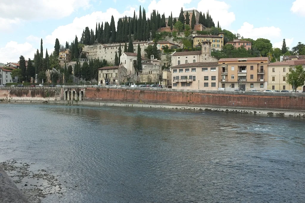 A sunny cobblestone street in Verona, Italy, ideal for September layered outfits